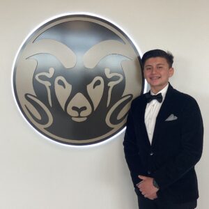 2023 Youth of the Year, Jose Guzman posing next to the Colorado State University logo