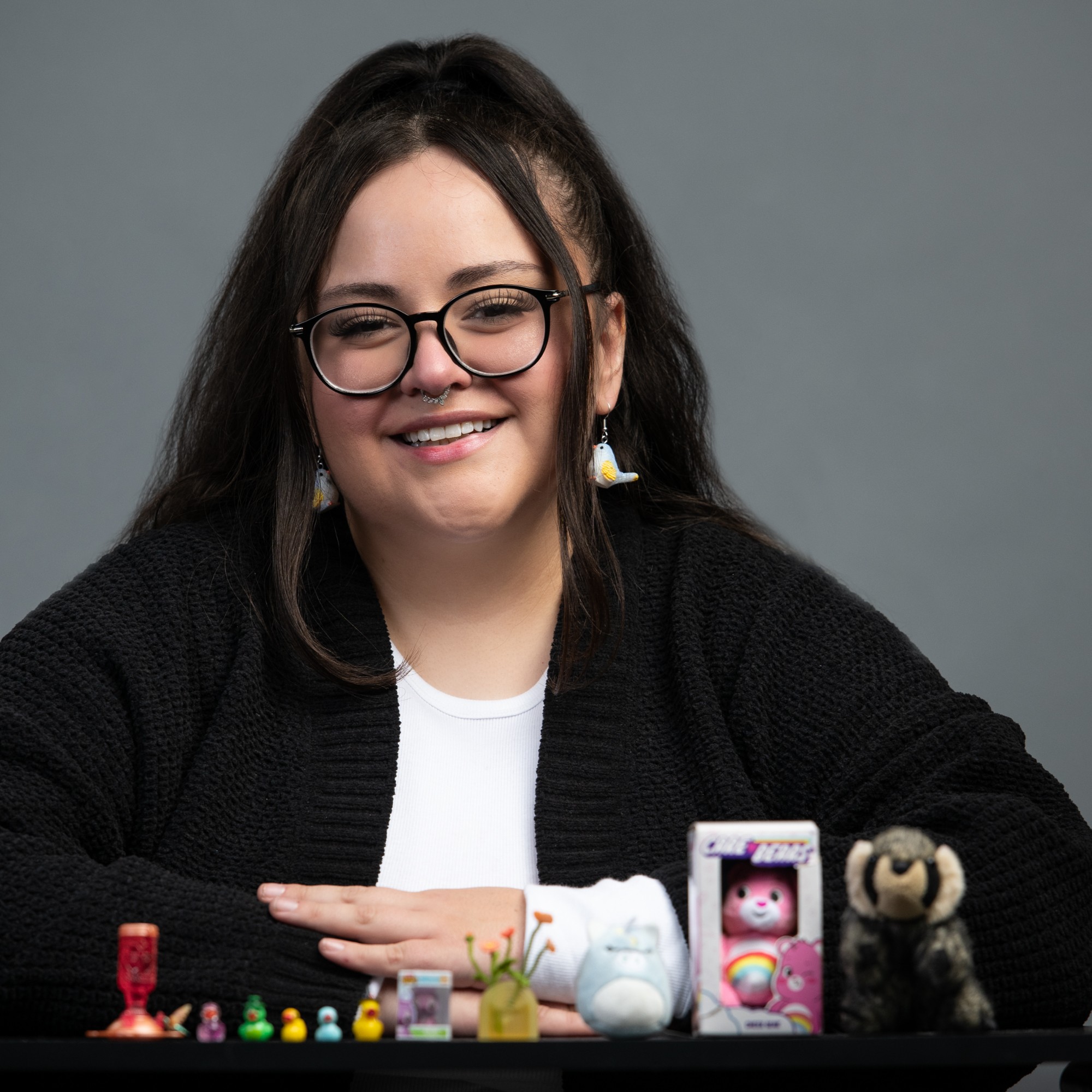 Alex Saenz toggle image, she is sitting with small versions of big things