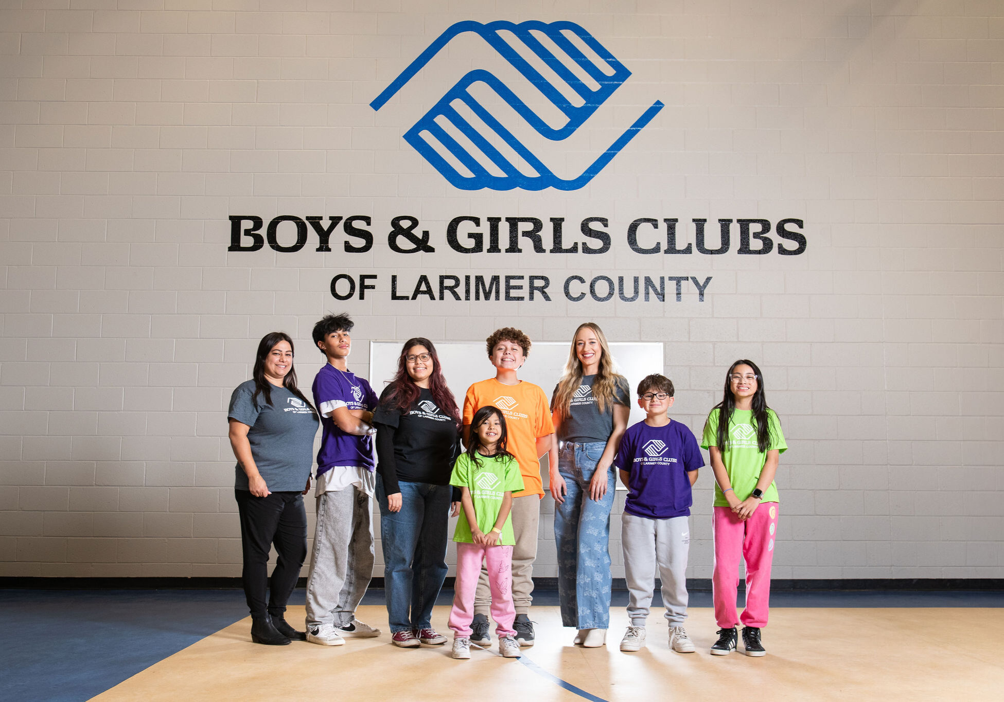 group photo showing Club members and alumni of different ages in front of the BGCLC logo